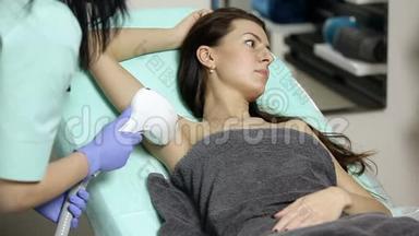 美容师对病人腋窝进行激光脱毛。 脱毛程序
